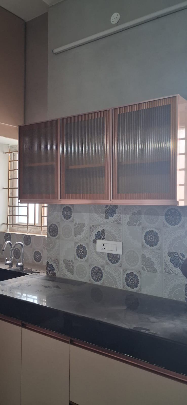 Pastel kitchen counter and cabinet design by Anjaneya Interiors