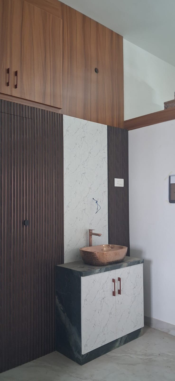 Modular kitchen with rose gold glass cabinet by Anjaneya Interiors