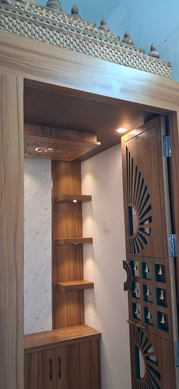 Pooja unit corner design with copper accents by Anjaneya Interiors