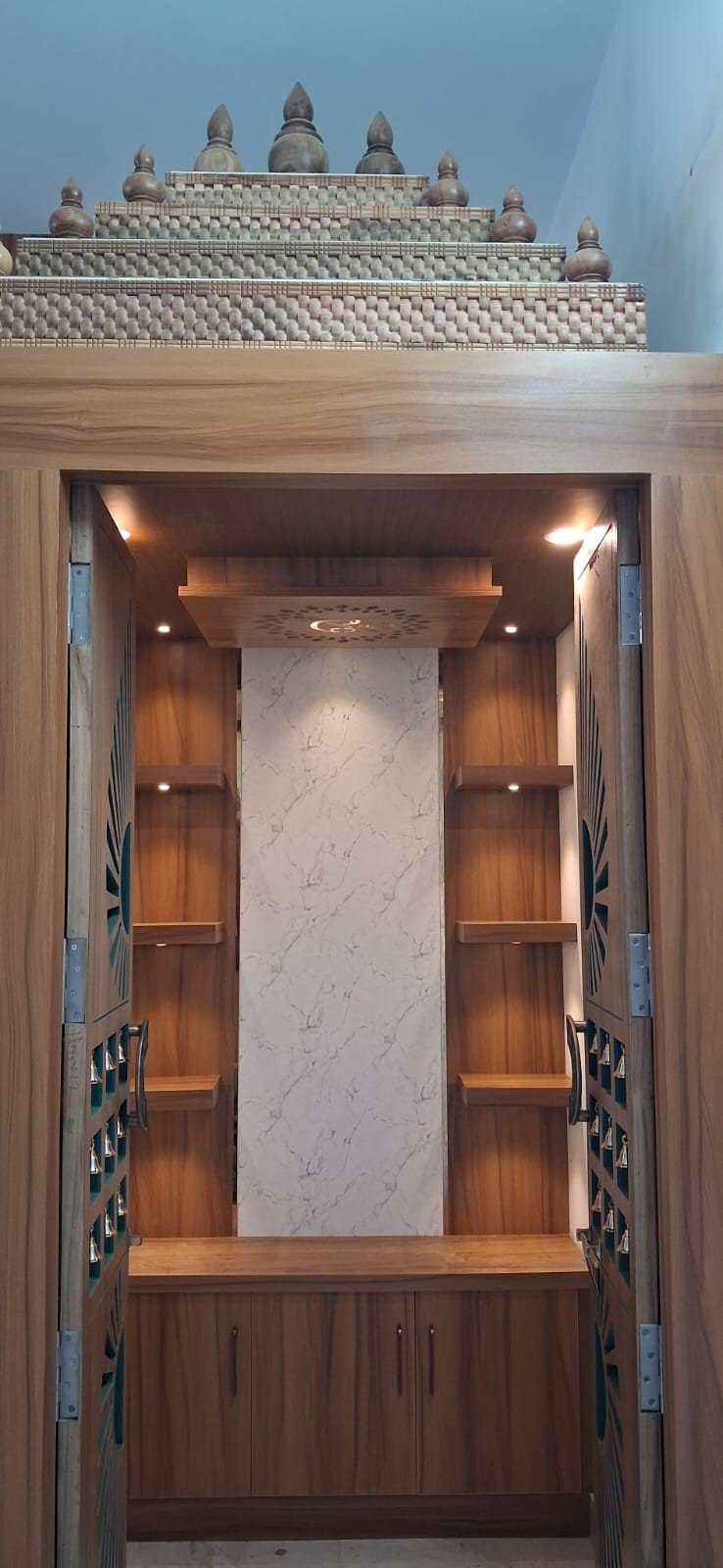 Pooja unit exterior with traditional bells by Anjaneya Interiors
