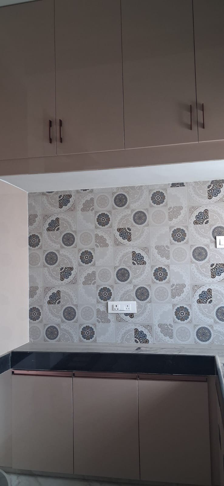 Modular kitchen with patterned tile backsplash by Anjaneya Interiors